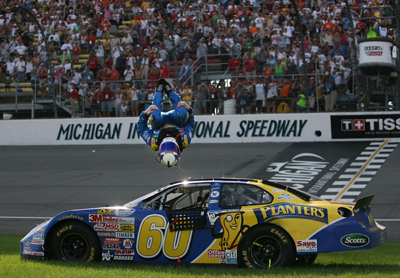 Carl Edwards, driver of the No. 60 Planters Ford, celebrates a win in his typical manner -- a backflip -- but this time kept his helmet on. Edwards, who also was the polesitter, won the NASCAR Nationwide CARFAX 250 on Saturday at Michigan International Speedway. (Photo Credit: Marc Serota/Getty Images for NASCAR)