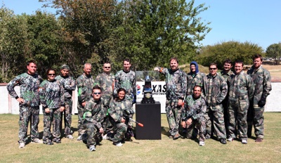 NASCAR Sprint Cup Series star Kyle Busch (immediate left of trophy) and Texas Motor Speedway President Eddie Gossage (immediate right of trophy) stand next to the Dickies 500 trophy and the participants in paintball warfare for a Texas Motor Speedway media event Tuesday, Sept. 30, at Fun On The Run Paintball Park in Fort Worth, Texas.