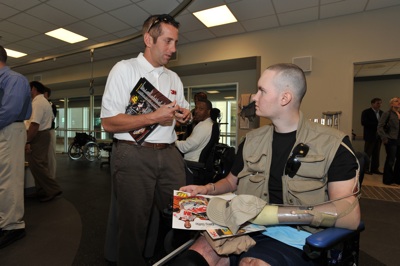 (Left to right) NASCAR Sprint Cup Series driver Greg Biffle signs an autograph for a soldier at Walter Reed Army Medical Center's Military Advance Training Center in Washington, D.C. NASCAR made its annual visit to the facility to salute the troops on Thursday. (Photo Credit: Larry French/Getty Images for NASCAR)