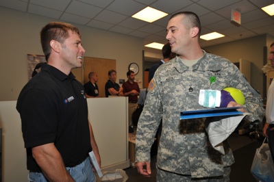 (Left to right) NASCAR Sprint Cup Series driver Scott Riggs visits a soldier at Walter Reed Army Medical Center in Washington, D.C. NASCAR made its annual visit to the facility to salute the troops on Thursday. (Photo Credit: Larry French/Getty Images for NASCAR)