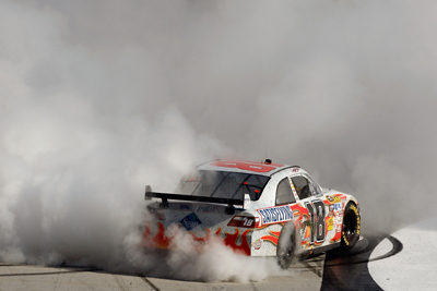Kyle Busch does a burnout on the frontstretch of Bristol Motor Speedway to celebrate his Food City 500 victory. (Photo Credit: Chris Graythen/Getty Images)