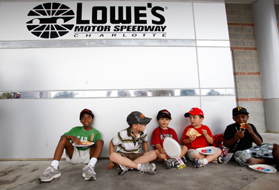 A group of kids enjoy some Domino's pizza while waiting out the rain delay at Lowe's Motor Speedway. (Photo Credit: Streeter Lecka/Getty Images for NASCAR)