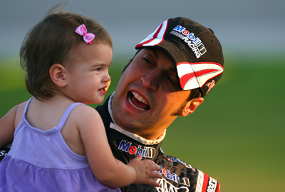 Sam Hornish Jr., driver of the No. 77 Mobil 1 Advanced Fuel Economy Dodge, shares a smile with daughter Addison while standing on pit road waiting to qualify for the Saturday's NASCAR Sprint Cup Series LifeLock.com 400 at Chicagoland Speedway in Joliet, Ill. (Photo Credit: Jason Smith/Getty Images for NASCAR)
