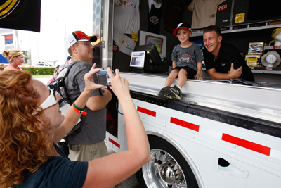 NASCAR Sprint Cup Series driver AJ Allmendinger meets a fan as his mother takes a picture at the NASCAR Sprint Cup Series Merchandise Hauler on Friday at Daytona International Speedway. (Photo Credit: Streeter Lecka/Getty Images)