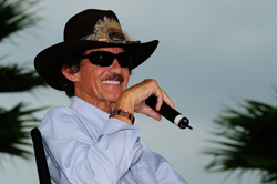 Seven-time NASCAR Sprint Cup Series champion Richard Petty talks with fans during a question-and-answer session at the the Sprint FanZone stage in the Daytona International Speedway infield Friday. Petty celebrates the 25th anniversary of his final and NASCAR Sprint Cup Series record 200th victory on July 4, 1984 at the track. (Photo Credit: Sam Greenwood/Getty Images)