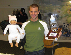 E.J. Viso with a baby doll and the winners trophy after winning the Daddy Boot Camp challenge (credit: Infineon Raceway)