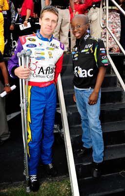 Carl Edwards, driver of the No. 99 Aflac Cancer Center Ford, stands with Jody Lawrence, a 13-year-old cancer patient from Atlanta who designed the color scheme for his Sprint Cup Series car for the NASCAR Sprint Cup Series Pep Boys Auto 500 at Atlanta Motor Speedway in Hampton, Ga. (Photo Credit: Rusty Jarrett/Getty Images for NASCAR)