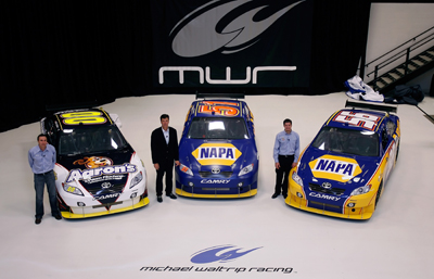 (Left to right) Michael Waltrip Racing's NASCAR Sprint Cup Series drivers David Reutimann, Michael Waltrip and Martin Truex Jr. pose with their rides Wednesday at MIchael Waltrip Racing in Cornelius, N.C. during the NASCAR Sprint Media Tour. (Credit: Jason Smith/Getty Images)