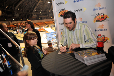 A young fan meets NASCAR Sprint Cup Series driver Elliott Sadler and gets an autograph on Saturday during the Sprint Sound and Speed Fan Festival at Nashville Municipal Auditorium in Nashville, Tenn. (Credit: Grant Halverson/Getty Images for NASCAR)