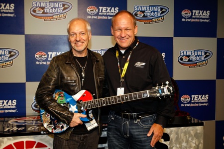 Musician Peter Frampton poses with artist Sam Bass and the special guitar Bass created for him in the deadline room Sunday at Texas Motor Speedway. (Credit: Chris Graythen/Getty Images)