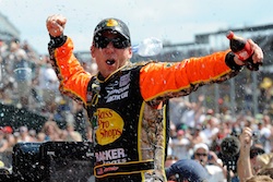 Jamie McMurray celebrates his Brickyard 400 victory at Indianapolis Motor Speedway. He became the third driver to win the Brickyard and the Daytona 500 in the same season. (Credit: John Harrelson/Getty Images for NASCAR)