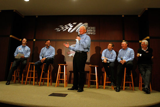Team owner Joe Gibbs (center) speaks about the 20th anniversary of Joe Gibbs Racing, as (left to right) JGR President J.D. Gibbs, former JGR drivers Tony Stewart and Bobby Labonte, JGR senior vice president of racing operations Jimmy Makar and Interstate Batteries CEO Norm Miller look on during the NASCAR Sprint Media Tour hosted by Charlotte Motor Speedway, held at Joe Gibbs Racing, on Thursday in Huntersville, N.C. (Credit: Jason Smith/Getty Images for NASCAR)