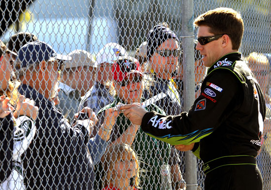 Carl Edwards signs autographs for fans after his qualifying lap Sunday at Daytona International Speedway in Daytona Beach, Fla. (Credit: Jerry Markland/Getty Images for NASCAR)
