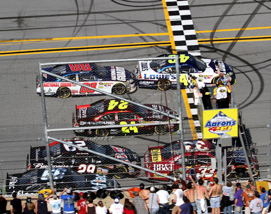 Fans watch Jimmie Johnson cross the finish line .002 seconds ahead of Clint Boywer at Talladega Superspeedway. Johnson's win ties the record for closest finish in NASCAR history. (Credit: Jerry Markland/Getty Images for NASCAR)