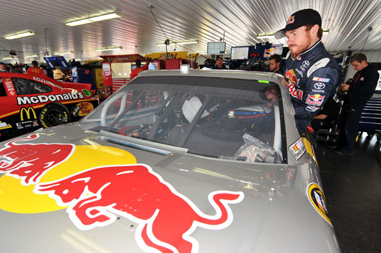 Brian Vickers, driver of the No. 83 Red Bull Toyota, climbs into his car in the garage area during practice for the NASCAR Sprint Cup Series 5-Hour Energy 500 at Pocono Raceway on June 10 in Long Pond, Pa. (Credit: Drew Hallowell/Getty Images for NASCAR)