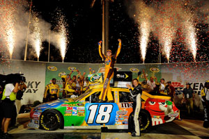 Kyle Busch climbs out of the No. 18 M&Ms in victory lane after winning the Quaker State 400 at Kentucky Speedway. (Credit: Jared C. Tilton/Getty Images for NASCAR)