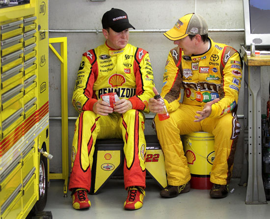 Kurt Busch (left), driver of the No. 22 Shell/Pennzoil Dodge, talks with his brother, Kyle Busch (right), driver of the No. 18 M&M's Toyota, during practice for the NASCAR Sprint Cup Series Brickyard 400 at Indianapolis Motor Speedway on July 29 in Indianapolis, Ind. (Credit: Jerry Markland/Getty Images for NASCAR)