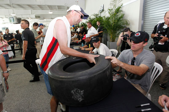 Kevin Harvick, driver of the No. 29 Budweiser Chevrolet autographs a tire for a race fan at the largest 2011 NASCAR Sprint Cup Series autograph session held at Indianapolis Motor Speedway on July 30 in Indianapolis, Ind. (Credit: Getty Images for NASCAR)