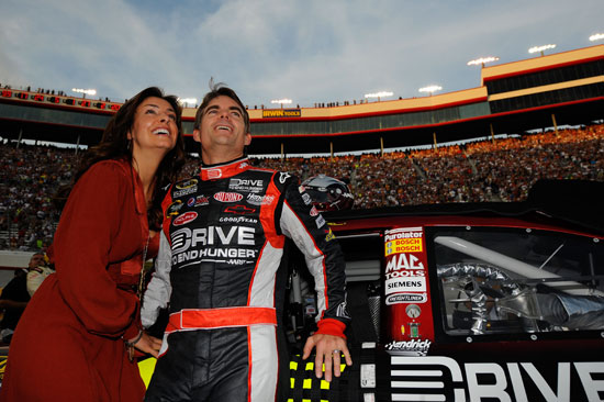 Five-time NASCAR Sprint Cup Series champion Jeff Gordon and wife Ingrid Vandebosch enjoy the prerace ceremony before the NASCAR Sprint Cup Series Irwin Tools Night Race at Bristol Motor Speedway on Saturday. (Credit: Jason Smith/Getty Images for NASCAR)