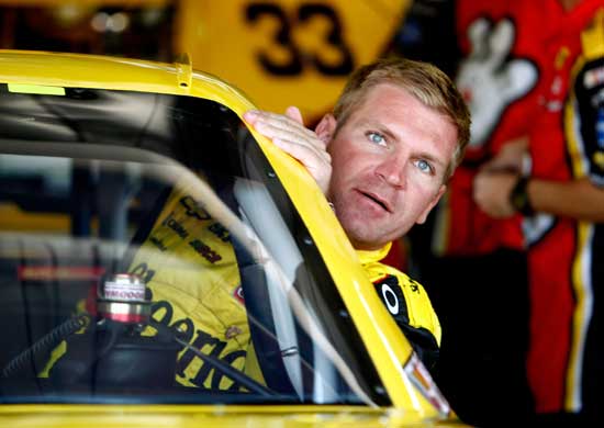 Clint Bowyer, driver of the No. 33 Cheerios/Hamburger Helper Chevrolet, climbs in his car in the garage during practice for the NASCAR Sprint Cup Series Pure Michigan 400 at Michigan International Speedway on Aug. 19 in Brooklyn, Mich. (Credit: Jeff Zelevansky/Getty Images for NASCAR)