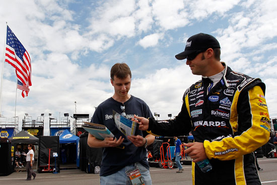 Paul Menard, driver of the No. 27 CertainTeed/Menards Chevrolet, signs autographs during practice for the NASCAR Sprint Cup Series Good Sam RV Insurance 500 at Pocono Raceway on Aug. 5 in Long Pond, Pa. Menard won the Brickyard 400 a week ago at Indianapolis Motor Speedway. (Credit: Geoff Burke/Getty Images for NASCAR)