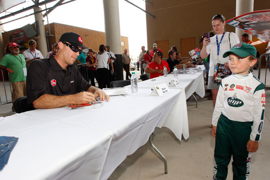 NASCAR Sprint Cup Series driver Kevin Harvick signs an autograph for a young fan at Atlanta Motor Speedway on Sept. 2 in Hampton, Ga. (Credit: By Geoff Burke/Getty Images for NASCAR)