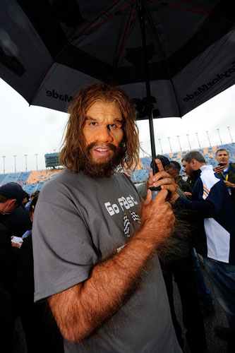 The GEICO Caveman, who will serve as Grand Marshal, walks out on the grid as rain falls prior to the NASCAR Sprint Cup Series GEICO 400 at Chicagoland Speedway on Sept. 18 in Joliet, Ill. (Credit: Jason Smith/Getty Images)