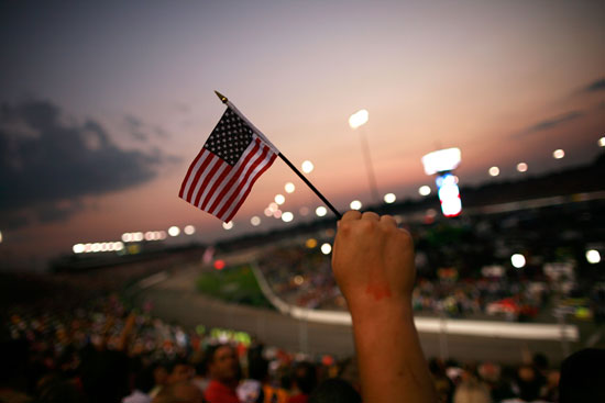 From laps 9-11, fans honor the 10th anniversary of the 9/11 terrorist attacks, staying silent for three circuits and waving American flags on Saturday at Richmond International Raceway. (Credit: Tom Pennington/Getty Images)