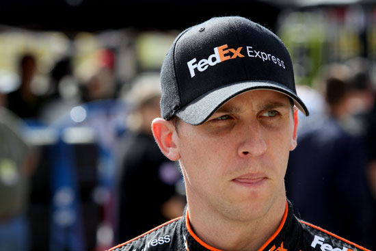 Denny Hamlin, driver of the No. 11 FedEx Express Toyota, walks in the garage area during practice for the NASCAR Sprint Cup Series Bank of America 500 at Charlotte Motor Speedway on Oct. 13 in Concord, N.C. (Credit: Jerry Markland/Getty Images for NASCAR)