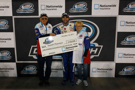 Elliott Sadler poses with Joseph Thornton and wife, winners of $100,000 in the NASCAR Nationwide Dash 4 Cash giveaway. (Credit: Geoff Burke/Getty Images for NASCAR)