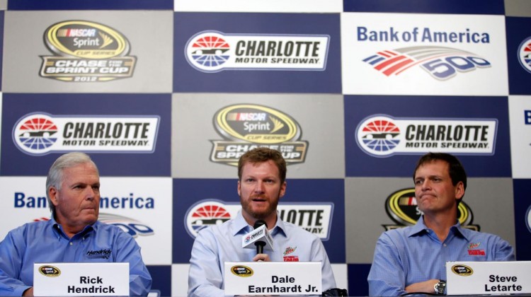 Dale Earnhardt Jr. (center), driver of the No. 88 Diet Mountain Dew Chevrolet, is flanked by Hendrick Motorsports team owner Rick Hendrick (left) and crew chief Steve Letarte (right) as he speaks to the media at Charlotte Motor Speedway on Oct. 11 in Charlotte, N.C. Earnhardt will miss two races after suffering a concussion from an accident in Talladega last week. (Credit: Chris Graythen/Getty Images)