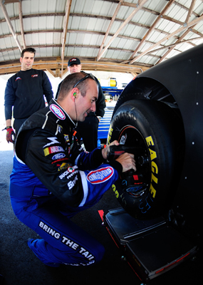Marcos Ambrose helps his No. 47 crew by working on his tires on Wednesday during the NASCAR Sprint Cup Series test at Pocono Raceway. (Photo Credit: Rusty Jarrett/Getty Images for NASCAR)