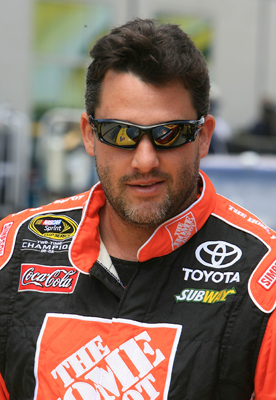 Tony Stewart is all smiles in the garage after unveiling his new car number and sponsors at Indianapolis Motor Speedway. (Photo Credit: Jerry Markland/Getty Images for NASCAR)