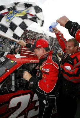Johnny Benson and his crew celebrate winning the Kroger 200 at Martinsville Speedway. The win moved Benson into first place in the point standings ahead of Ron Hornaday Jr. (Photo Credit: Jason Smith/Getty Images for NASCAR)