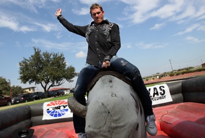 NASCAR Sprint Cup Series driver Scott Speed (right) hangs on during his maiden ride on a mechanical bull in the Fort Worth Stockyards Tuesday, October 21, 2008. (Photo By Tom Pennington/Getty Images for the Texas Motor Speedway)