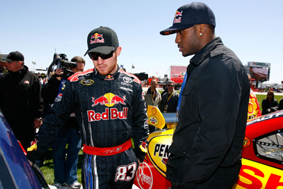 (Left to right) NASCAR Sprint Cup Series driver Brian Vickers talks about his No. 83 Red Bull Toyota with New Orleans Saints running back Reggie Bush before Sunday's Samsung 500 at Texas Motor Speedway in Fort Worth, Texas. (Photo Credit: Jason Smith/Getty Images for NASCAR)
