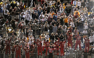 The crew members of Tony Stewart's No. 14 Office Depot Chevrolet climb the fence to salute the fans after winning the NASCAR Sprint All-Star Race at Lowe's Motor Speedway. (Photo Credit: Drew Hallowell/Getty Images for NASCAR)
