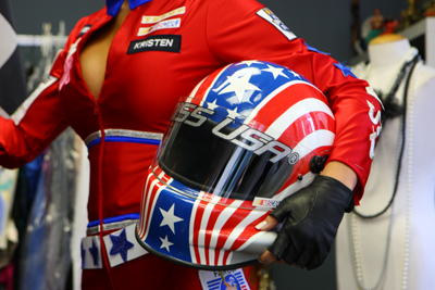 A closeup reveals the NASCAR bar logo on the chest and a NASCAR Hall of Fame logo on the left arm of 2009 Miss USA Kristen Dalton's NASCAR-themed costume for the Miss Universe Pageant. Dalton modeled the costume at Miss Universe Pageant Headquarters in New York City. (Photo Credit: Mike Stobe/Getty Images for NASCAR)