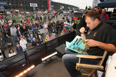 NASCAR Sprint Cup Series driver of the No. 39 Chevrolet Ryan Newman reads a book to children in the FanZone as part of 