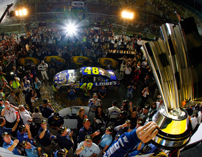 Hendrick Motorsports teammates look on as Jimmie Johnson hoists the Sprint Cup trophy for the fourth consecutive season. (Photo Credit: Rusty Jarrett/Getty Images for NASCAR)