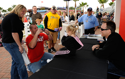 NASCAR Sprint Cup Series driver Kevin Harvick poses for a photo with a young fan during autograph sessions on Saturday at NASCAR Preseason Thunder Fan Fest at Daytona International Speedway in Daytona Beach, FL. (Credit: Rusty Jarrett/Getty Images for NASCAR)