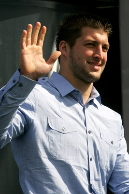 Former University of Florida quarterback Tim Tebow waves to fans in the stands before giving drivers the command to start their engines Thursday to start the first NASCAR Sprint Cup Series Gatorade Duel at Daytona International Speedway. (Credit: Jerry Markland/Getty Images for NASCAR)