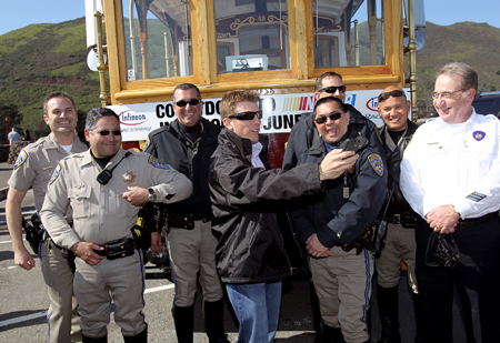Daytona 500 champion Jamie McMurray jokes with members of the California Highway Patrol before he boarded a cable car for his victory tour of San Francisco on February 17, 2010 in San Francisco, California. (Photo by Ezra Shaw/Getty Images)