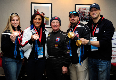 Bronze medalist members of the U.S. Olympic woman's bobsled driver Erin Pac, poses along with team brakeman Elana Meyers, NASCAR driver Geoff Bodine, head of the Bodine bobsled project, gold-winning men's bobsled team pilot Steve Holcomb and pushman Steve Mesler in the media center at Atlanta Motor Speedway. (Credit: Rusty Jarrett/Getty Images for NASCAR)