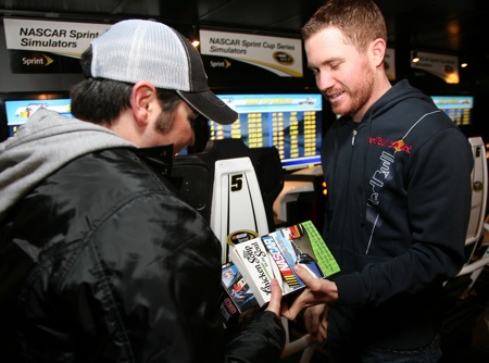 Brian Vickers congratulates Matt Dettelbach (@mdbach on Twitter) for beating him in the simulator race at the Sprint Experience. (Photo by Jerry Markland/Getty Images for NASCAR)