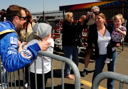 Lucky fans pose for a photo with former NASCAR Sprint Cup Series Champion Kurt Busch as he takes a break during the second day of testing in Concord, N.C. (Credit: Rusty Jarrett/Getty Images for NASCAR)