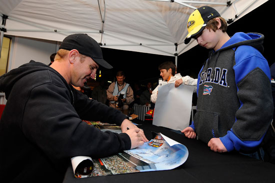 Clint Bowyer signs autographs for fans during Preseason Thunder on Friday at Daytona International Speedway in Daytona Beach, Fla. (Credit: Jared C. Tilton/Getty Images for NASCAR)