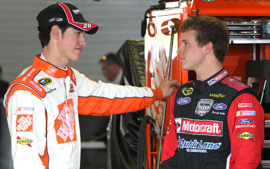(Left to right) NASCAR Sprint Cup Series drivers Joey Logano and Trevor Bayne talk in the garage during practice Friday at Talladega Superspeedway in Talladega, Ala. (Credit: Jerry Markland/Getty Images for NASCAR)