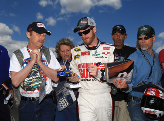 Dale Earnhardt Jr., driver of the No. 88 National Guard/Amp Energy Chevrolet, signs autographs in the garage area during practice for the NASCAR Sprint Cup Series Crown Royal Presents The Matthew and Daniel Hansen 400 at Richmond International Raceway on Apr. 29 in Richmond, Va. (Credit: Streeter Lecka/Getty Images)