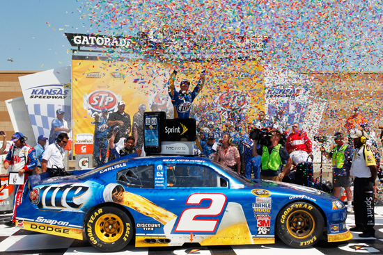 Brad Keselowski climbs out of the No. 2 Miller Lite Dodge in victory lane after winning the STP 400 (Credit: Geoff Burke/Getty Images for NASCAR)